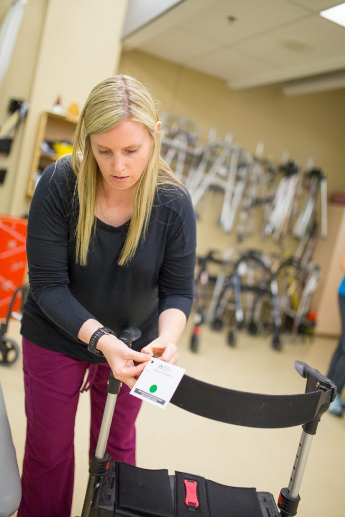 Healthcare worker affixes sticker to patients walker