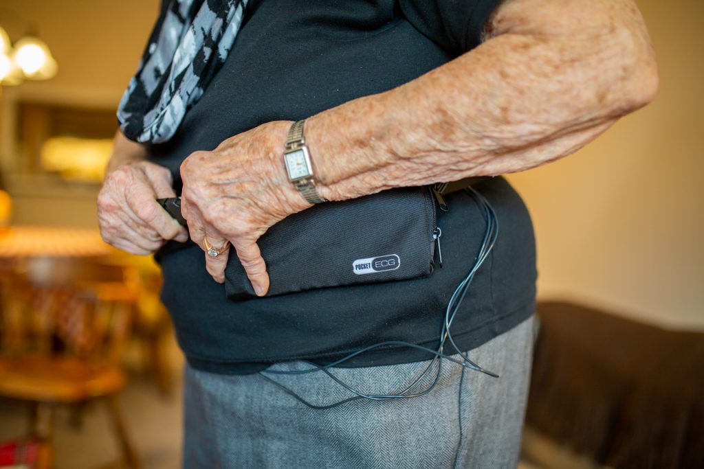Patient putting on the pouch with the remote heart monitor