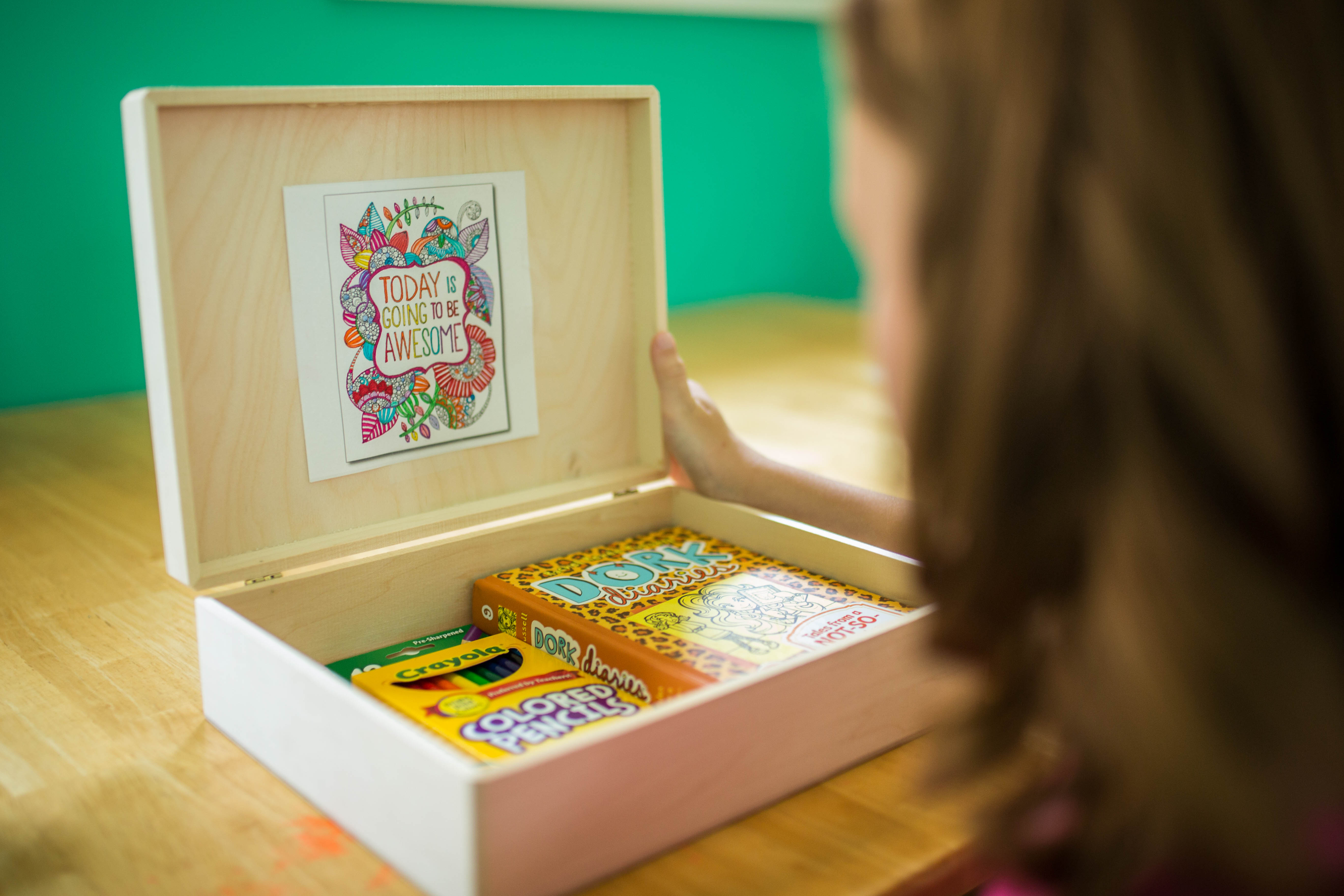 Kayla's coping box contains items like colouring pencils and books 