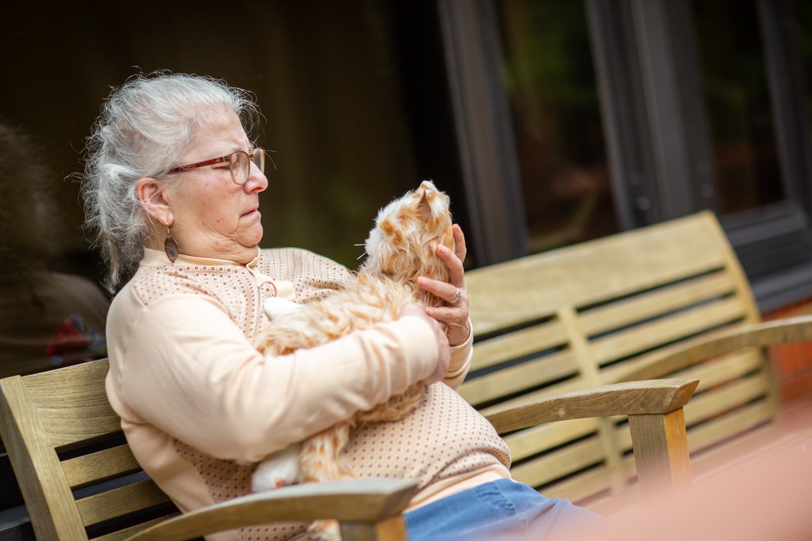 Gail holds an orange robotic cat and looks at her quizzically