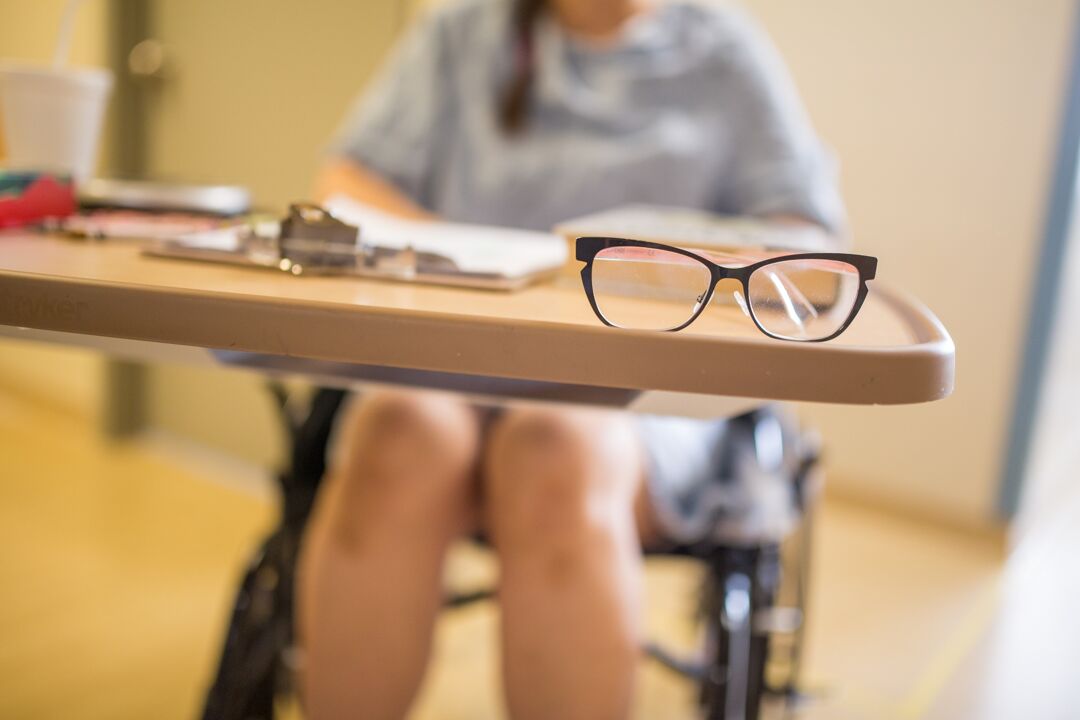 a pair of glasses sit on a patients bedside table