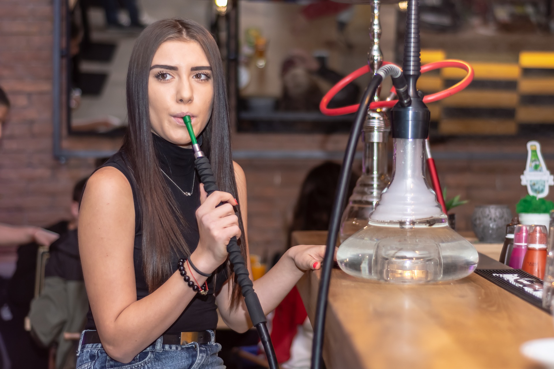 A young woman smoking from a hookah pipe