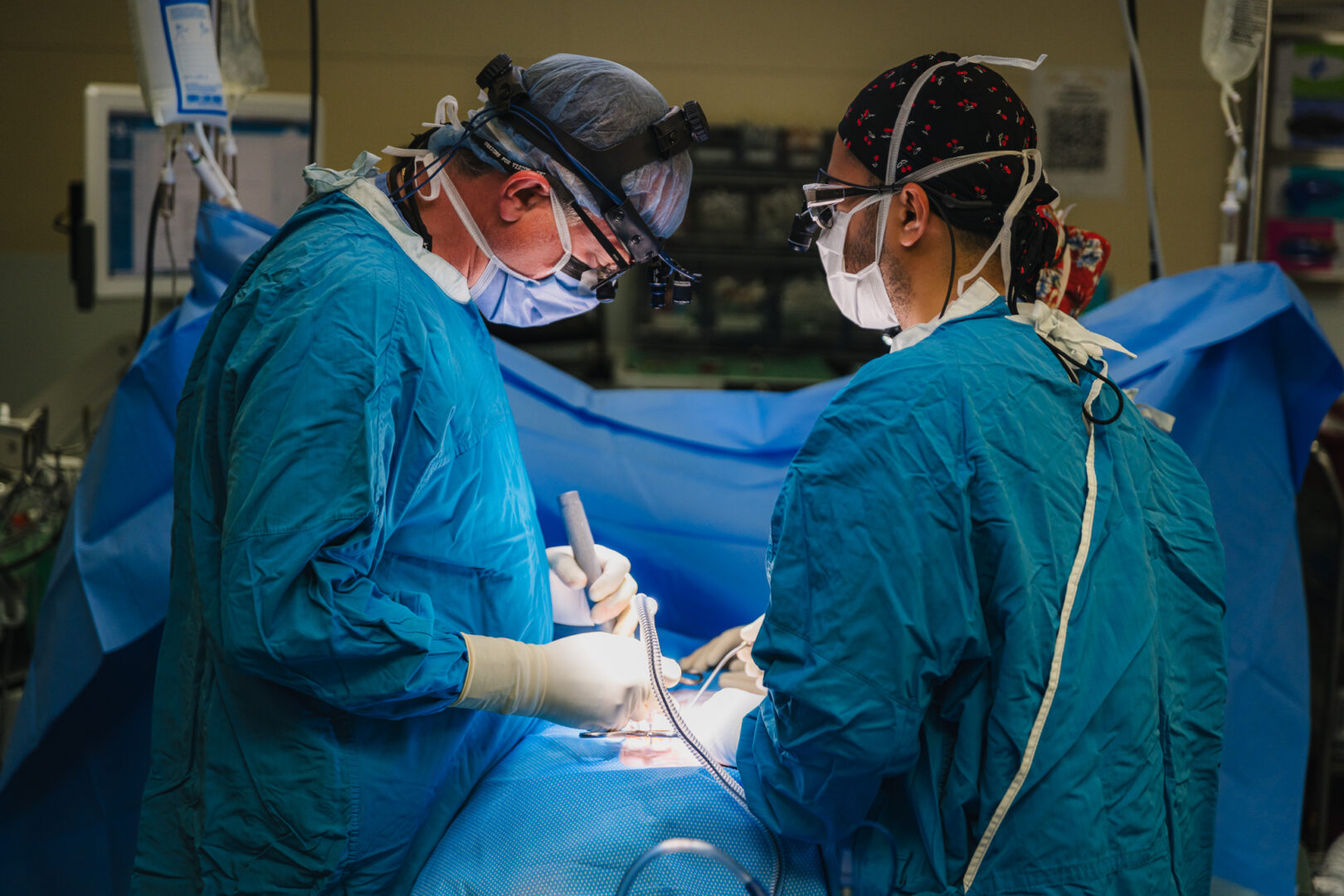 A surgeon operates on a patient, wearing a head camera