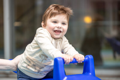 One year old Nathan smiling pushing a walker
