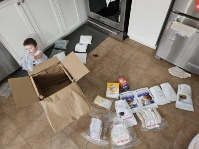 Nathan sitting on the floor surrounded by specialty food packages that were just delivered