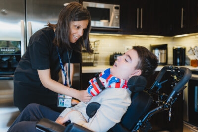 Nurse practitioner Emily Skoutarou caring for Meric in his wheelchair