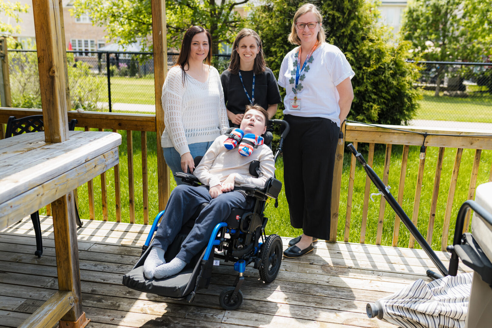 Meric in his wheelchair surrounded by his mom Lisa, nurse practitioner Emily Skoutarou and clinical specialist Cindy Van Halderan