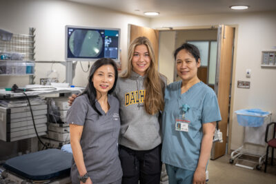 Dr. Tse, Daisy and another health care provider in a hospital room. All are standing close together.