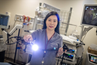 Dr. Tse holds an endoscopy tool. The light shines into the camera.