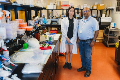 Grade 12 student Grace Lee with one of her mentors, Dr. Sandeep Raha, standing in the Raha Lab in HHS McMaster University Medical Centre.